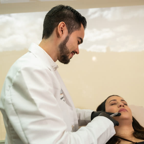 El Dr. Alejandro Villanueva Sáenz realiza un procedimiento en el rostro de una paciente